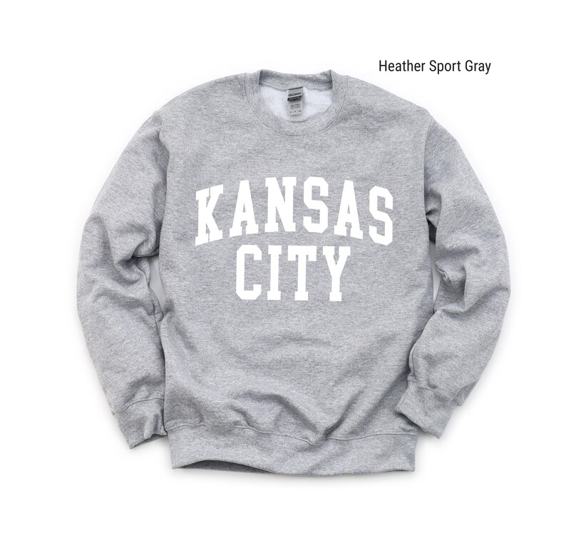 May include: A heather sport gray sweatshirt with the text "KANSAS CITY" printed in white on the front.