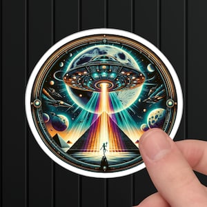 May include: A round sticker with a colorful illustration of a UFO hovering over a pyramid. The UFO is emitting a beam of light that illuminates the pyramid. The background is a dark blue with stars and planets.
