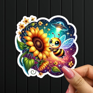 May include: A colorful sticker featuring a cartoon bee with a spaceship above it, flying towards a sunflower with a galaxy background.