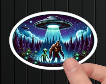 May include: A sticker featuring a green alien and a Bigfoot standing in a forest at night, with a UFO hovering above them.