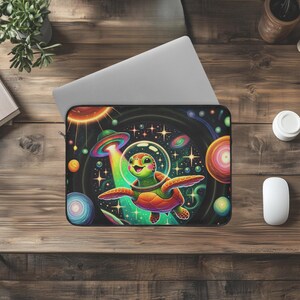 May include: A colorful laptop sleeve featuring a cartoon turtle wearing a space helmet and flying through a galaxy with stars and planets. The turtle is green, orange, and yellow, and the galaxy is a vibrant mix of blues, purples, and pinks.