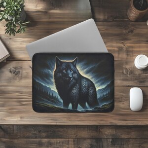May include: Black wolf with blue and white tribal tattoos standing in a dark forest with a stormy sky in the background. The wolf is looking directly at the viewer.