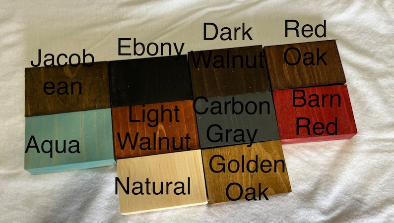 May include: Wood stain colour samples in various shades of brown, red, grey, and black. The samples are labelled with names like "Jacob ean", "Ebony", "Dark Walnut", "Red Oak", "Light Walnut", "Carbon Grey", "Barn Red", "Aqua", "Natural", and "Golden Oak".