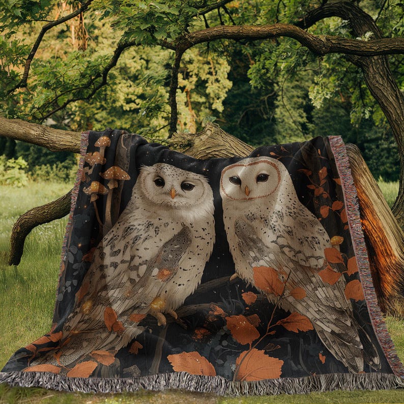 Two snowy white owls perched together surrounded by autumn leaves and luminous mushrooms against a starlit dark sky, woven on cotton throw blanket with decorative fringe