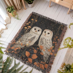 Enchanted forest throw blanket featuring pair of mystical white owls under starry night sky with golden autumn leaves and glowing mushrooms, cotton woven design