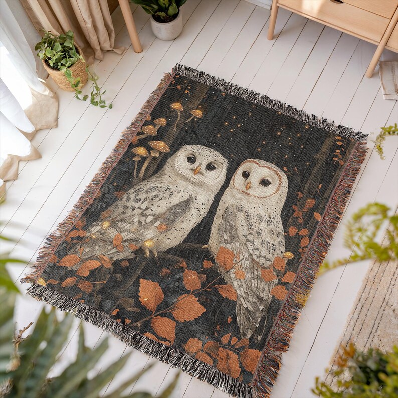 Enchanted forest throw blanket featuring pair of mystical white owls under starry night sky with golden autumn leaves and glowing mushrooms, cotton woven design