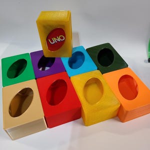 May include: Nine colorful card holders with a round opening for holding cards. The top holder is yellow and has the word "UNO" printed on it.