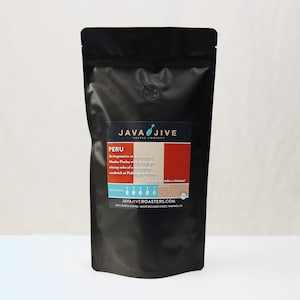 May include: A black bag of coffee beans labeled "Java Jive Coffee Company" with the text "Peru" and a description of the coffee beans. The bag is on a white surface.
