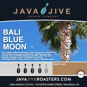 May include: A blue and white coffee bag with a palm tree and a blue sky. The bag is labeled "Bali Blue Moon" and features the text "JAVAJIVE COFFEE COMPANY". The bag is 12 ounces.
