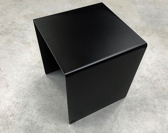 Könnte beinhalten: Ein schwarzer Beistelltisch aus Metall mit quadratischer Tischplatte und einem einzigartigen offenen Design. Der Tisch hat eine glatte, matte Oberfläche.