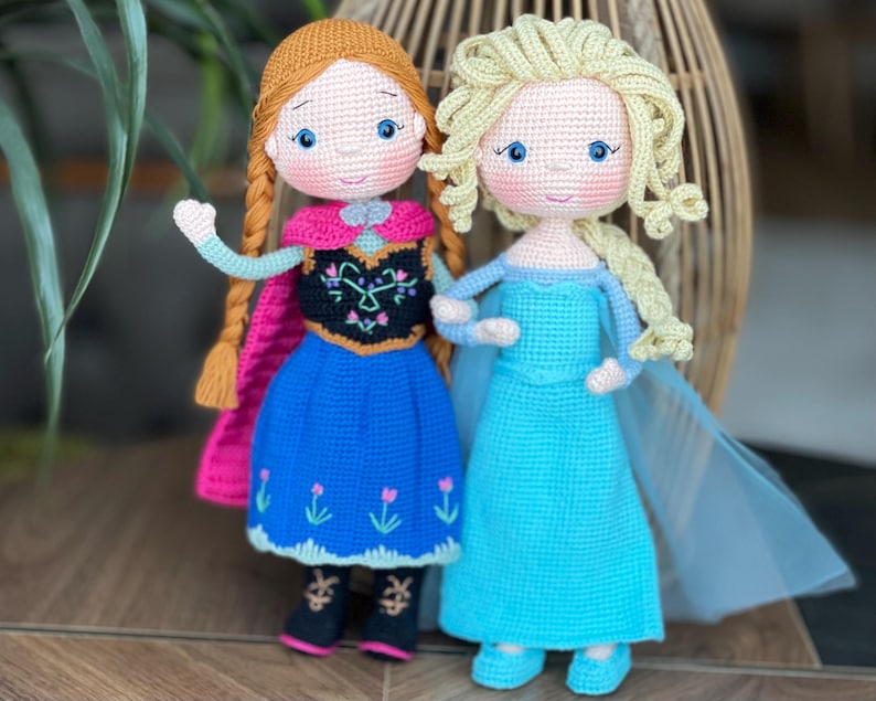 Handmade crocheted amigurumi dolls of Elsa and Anna, inspired by Frozen. Detailed with colorful outfits, perfect for custom name personalization or gifting.