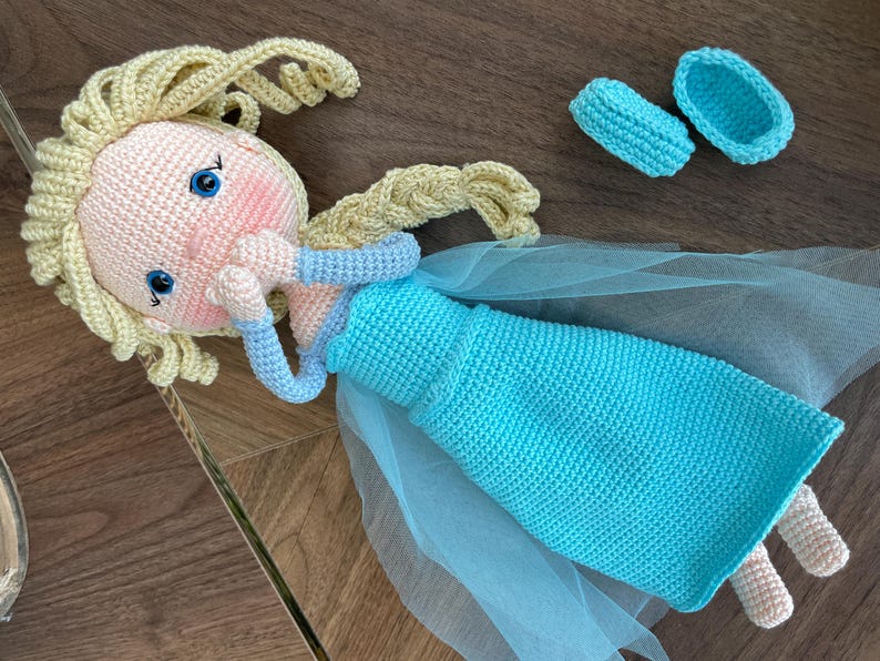 Handmade crocheted amigurumi dolls of Elsa and Anna, inspired by Frozen. Detailed with colorful outfits, perfect for custom name personalization or gifting.