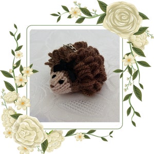 May include: A brown knitted hedgehog keychain with a black bow. The hedgehog has a small, white face with black eyes.