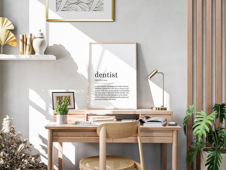 May include: A minimalist home office desk with a framed print that reads "dentist | /ˈdɛntɪst/ | noun | a skilled professional who keeps your teeth in tip-top condition, making sure your grin is always in top position. With their dental weaponry and sparkling wit, they make a visit to the dentist feel like a bit of a treat. They are the true champions of the dental world, keeping your teeth shining like pearls and your gum healthy and nourished."
