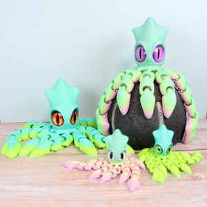 May include: A collection of colorful octopus figurines in various sizes. The figurines feature a mint green body with gradient tentacles in shades of yellow, pink, and purple. The eyes are orange or purple. The octopus figurines are on a wooden surface.
