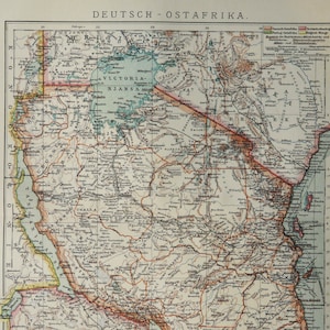 May include: A vintage map of German East Africa, showing the borders of the colony and its major cities and towns. The map is printed in black and white with colored lines and dots to indicate different geographical features. The map is titled "Deutsch-Ostafrika" and includes a legend explaining the different symbols used.