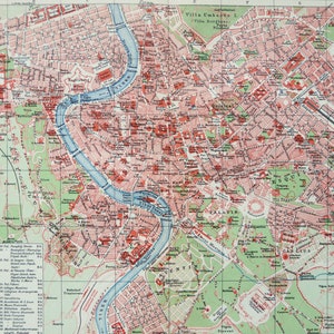 Puede incluir: Un mapa impreso de estilo antiguo de Roma, Italia, que muestra el sinuoso río Tíber en azul, cuadrículas de calles urbanas en tonos rojos y beige, y zonas verdes de parques. El mapa incluye un sistema de cuadrícula, una leyenda y texto en alemán.