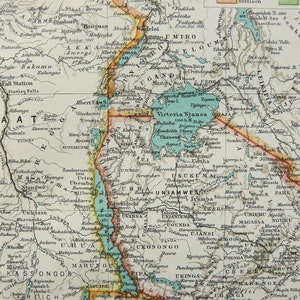 Könnte beinhalten: Eine Vintage-Karte von Ostafrika, die die Grenzen verschiedener Länder und Regionen zeigt, darunter Uganda, Kenia, Tansania und Kongo. Die Karte ist in Schwarzweiß gedruckt mit farbigen Rändern und Wassermerkmalen.