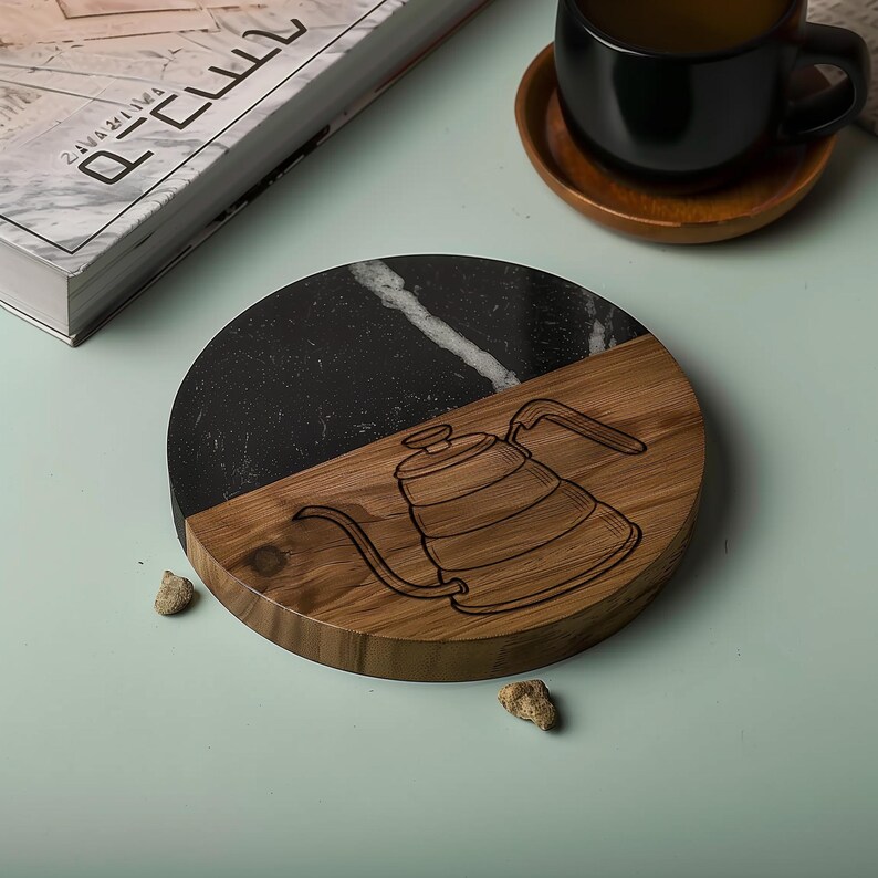a wooden coaster with a black marble design, a black coffee cup, and a book on a light blue surface.