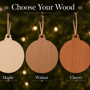 three wooden ornaments hanging from a tree branch, each with a different color: a light brown orchid, a light brown walnut, and a dark brown cherry.