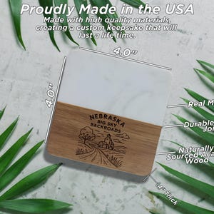 a marble coaster with a wooden design, surrounded by green leaves.