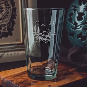 UFO Crash Site Pint Glass – Alien Spaceship Wreckage Scene with Forest, Mountains, and Stars – Sci-Fi Themed Glassware