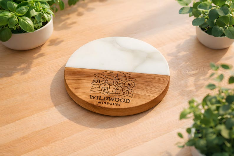 a wooden cutting board with a carved design and text, surrounded by potted plants on a wooden surface.