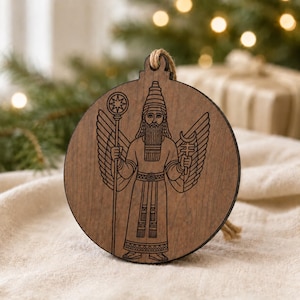 May include: A round, wooden Christmas ornament featuring an engraved image of a bearded figure with wings, holding a staff and a crescent-shaped object. The ornament has a natural wood grain finish and a jute string for hanging. The design is detailed and intricate.