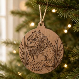 May include: Wooden Christmas ornament featuring a detailed illustration of a creature with a long beard and spiky head. The ornament is round with a natural wood finish and a jute string for hanging. The creature is depicted in a watery environment.