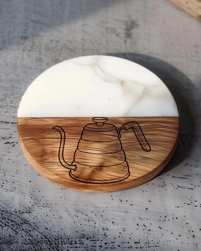A wooden coaster with a white and brown design featuring a coffee pot.