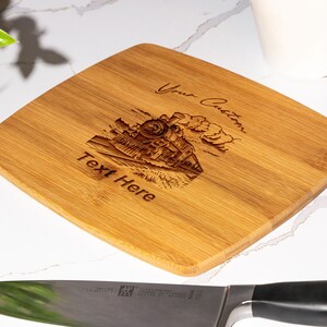 May include: A square, light brown bamboo cutting board with a laser-engraved image of a steam train and the text "Your Custom Text Here".