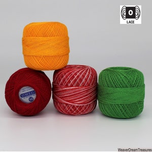 May include: Four balls of yarn in different colors: orange, red, white, and green. The yarn is labeled "OMEGA 100% Cotton 100% Algodon 30 Grams Net 10".