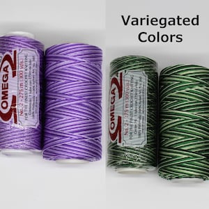 May include: Two spools of variegated nylon thread, one purple and white, the other green and white. Each spool is labeled "OMEGA No. 2 - 275 m (300 yds.) FOR THE FINEST CROCHET KNITTING".