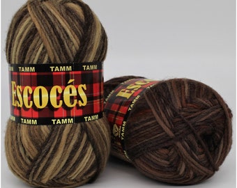 May include: Two skeins of brown, beige, and tan yarn with the word "Escocés" printed on the label. The label has a red and black plaid pattern with the word "TAMM" printed on it.