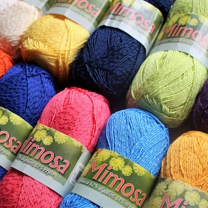 May include: A collection of colourful yarn skeins with the label "Mimosa" and the text "62% algod&oacute;n, 38% rayon".