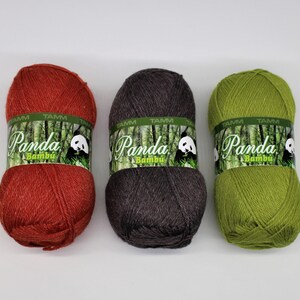 May include: Three skeins of yarn in red, brown, and green. Each skein has a label that says "Panda Bambu" with a panda bear illustration.