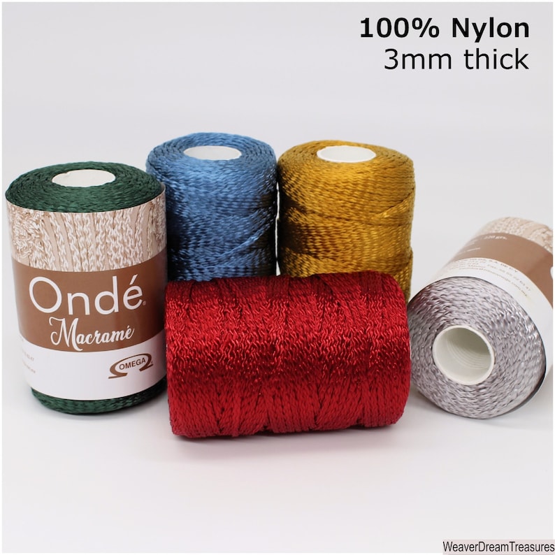 May include: Five spools of 3mm thick 100% nylon macrame cord in green, blue, gold, red, and silver. The spools are labeled "Ond&eacute; Macrame" with the Omega logo.