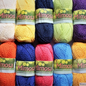 May include: A collection of 12 balls of Mimosa yarn in various colours, including red, white, yellow, blue, green, purple, and grey. Each ball has a label that reads "Mimosa 62% Acrylic 38% Nylon".