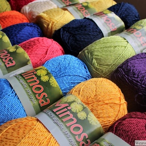 May include: A collection of colourful yarn skeins with the label "Mimosa" and the text "62% algod&oacute;n, 38% rayon".