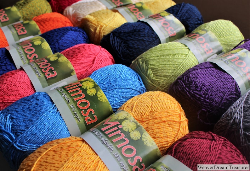 May include: A collection of colourful yarn skeins with the label "Mimosa" and the text "62% algod&oacute;n, 38% rayon".
