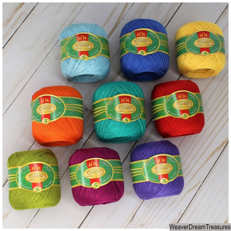 May include: Ten balls of cotton yarn in various colors, including orange, red, yellow, green, blue, purple, and turquoise. Each ball has a label with the text "OMEGA" and "5" printed on it.