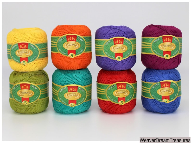 May include: Eight balls of yarn in various colors, including yellow, orange, green, teal, red, purple, and blue. Each ball has a label that reads "OMEGA" and "CROCHET 100% COTTON".