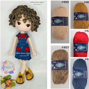 Puede incluir: Mu&ntilde;eca de crochet con cabello rizado marr&oacute;n, vistiendo una camisa roja, un mono azul con corazones rojos y zapatos marrones. La imagen tambi&eacute;n muestra diferentes colores de hilo con el texto "Sinfonia" en las etiquetas.