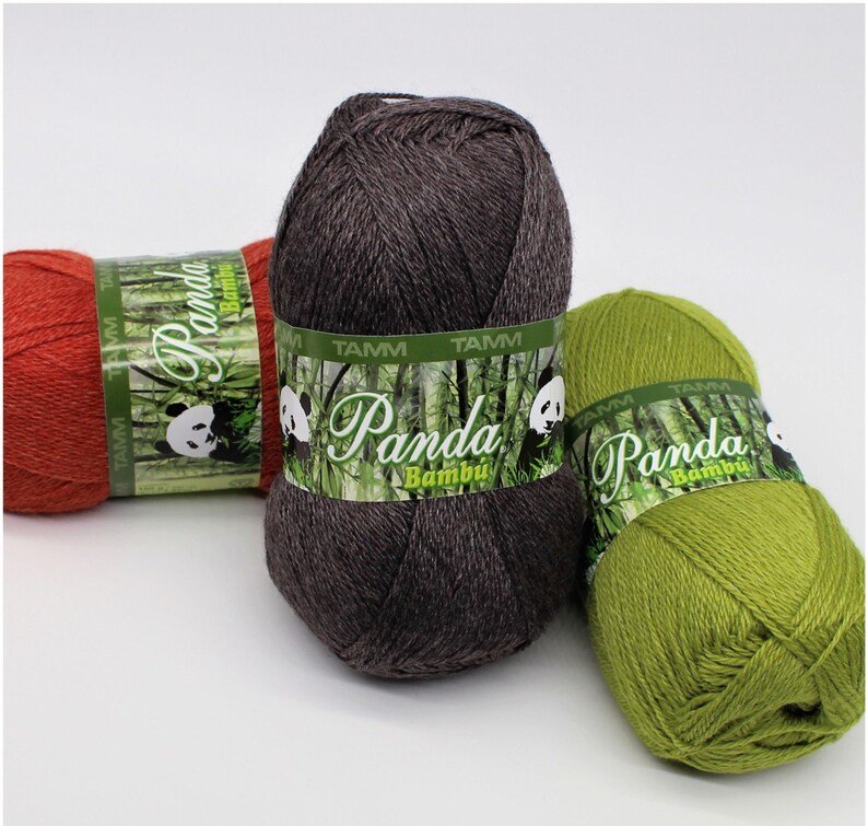 May include: Three skeins of yarn in different colors: red, gray, and green. Each skein has a label that says "Panda Bambu" with a panda bear and bamboo design.