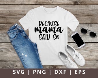 May include: White t-shirt with the text "Because mama said so" in black lettering. The shirt is laying on a wooden surface with a pair of jeans, a pair of sunglasses, and a phone.