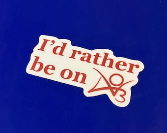 May include: A white sticker with red text that reads "I'd rather be on" above a red graphic. The sticker is on a blue background.