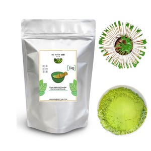 Puede incluir: Una bolsa plateada de polvo de té verde etiquetada con "AKI MATCHA 抹茶" con el texto "純茶抹の茶湯" y "[1kg]" en la parte delantera. La bolsa está sobre una superficie blanca. El texto "Pure Matcha Powder Ceremonial Grade" y "WWW.AKIMATCHA.COM" también están en la parte delantera de la bolsa.