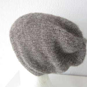 Könnte beinhalten: Eine graue Strickmütze mit einem lockeren Sitz.