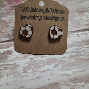 Heart shaped wood soccer stud earrings. Laser engraved cherry wood and hand painted. On hypoallergenic stainless steel posts