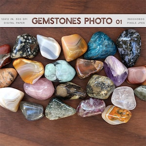 May include: A collection of 20 smooth, polished gemstones in various colors and patterns, including green, blue, purple, pink, red, brown, and white. The stones are arranged on a wooden surface. GEMSTONES PHOTO 01 3600x3600 PIXELS JPEG